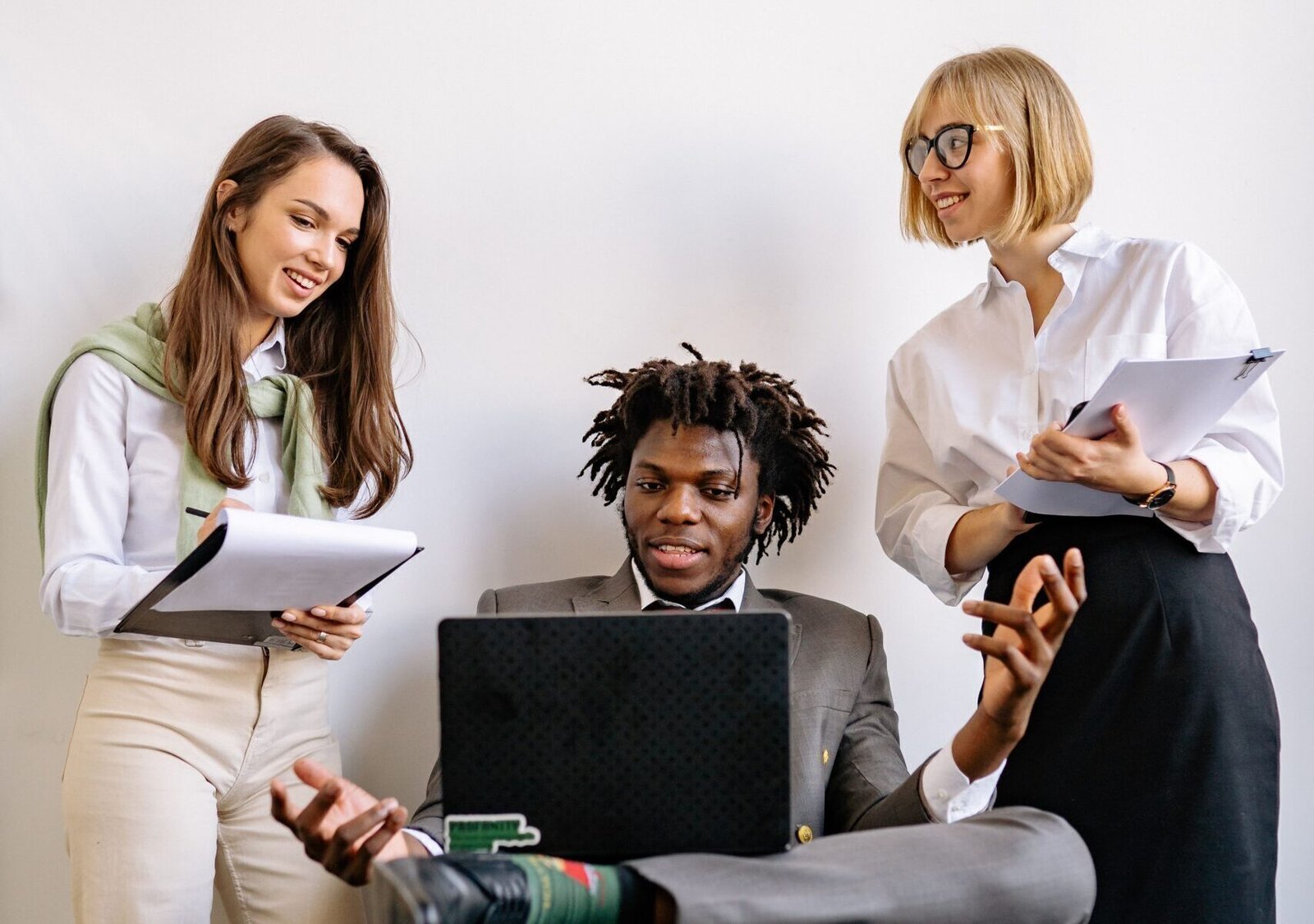 Three professionals engaged in a collaborative discussion in a modern office setting.